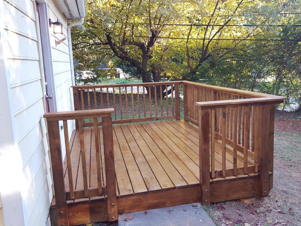 Tiny wooden deck installed at the back door of the house