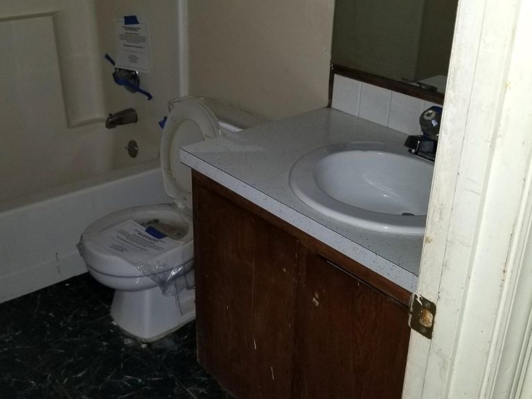 Partial view of a bathroom with out of order toilet bowl