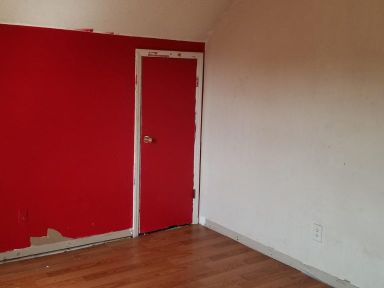 Original design of a bedroom with red painted wall before the renovation