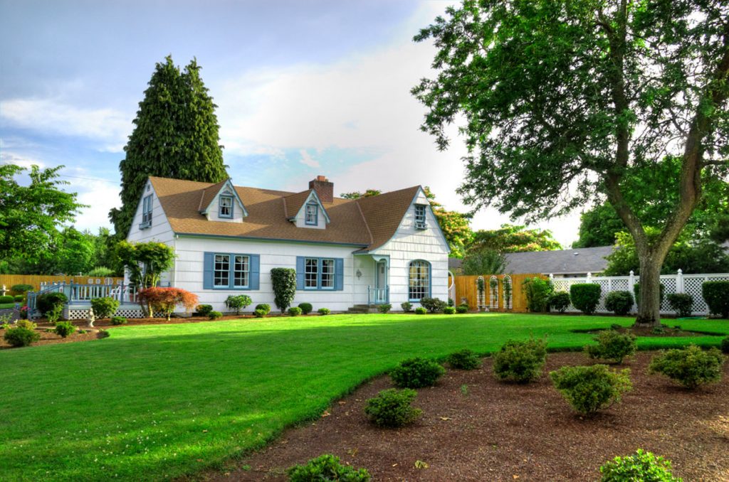 An overview of a residential house with a landscape grass and trees